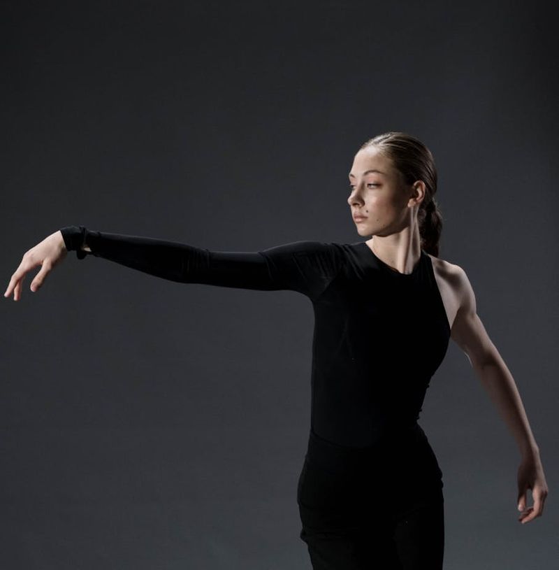 Woman performing a fluid yoga sequence in a spacious studio.